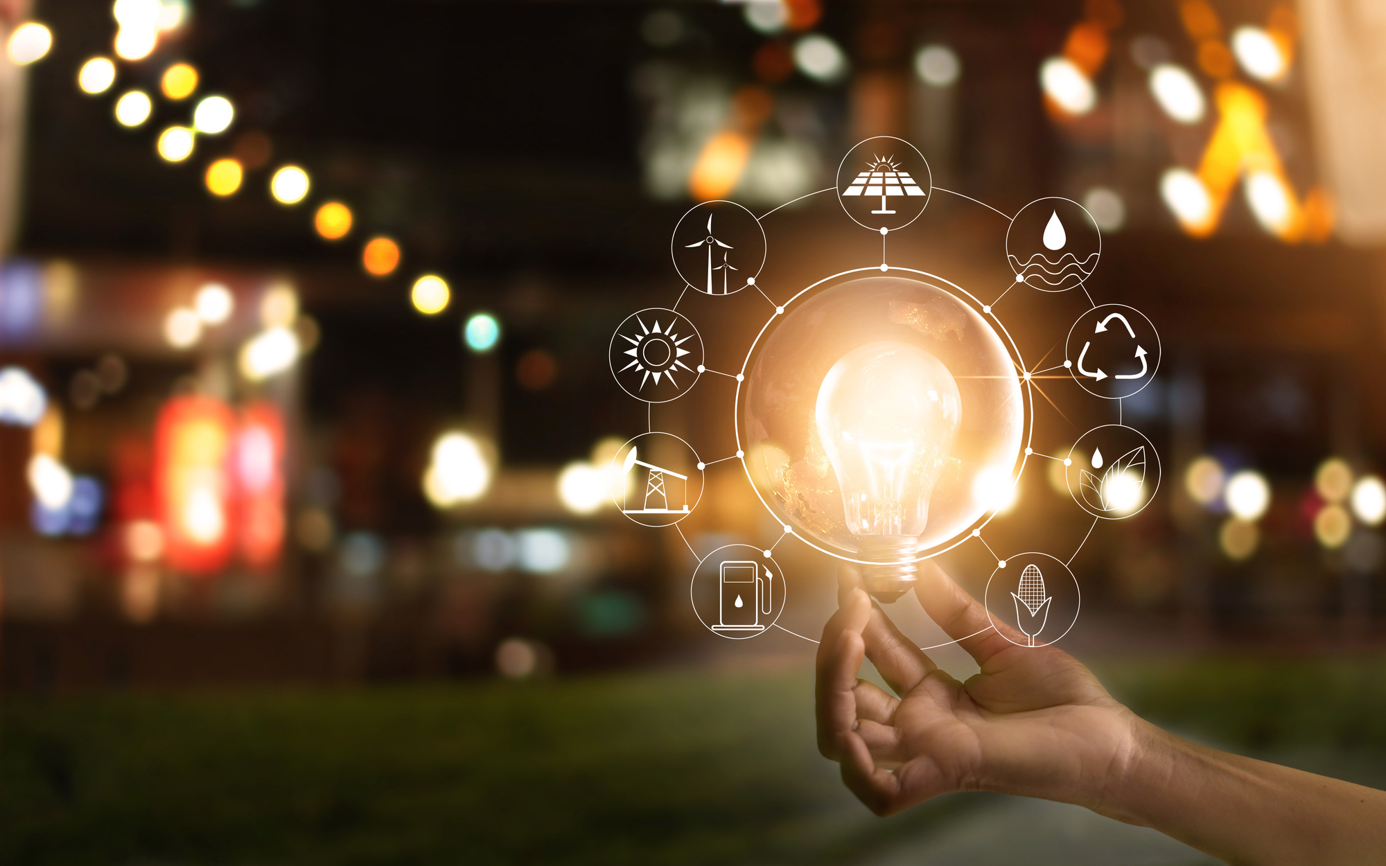 Hand holding a glowing light bulb for clean energy innovation